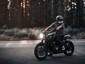 A man riding a motorcycle in the woods.