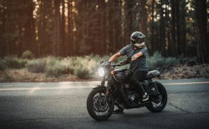 A man riding a motorcycle in the woods.