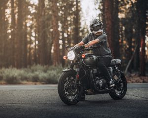 A person riding a motorcycle in the woods.