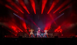 A group of dancers on stage with red lights.