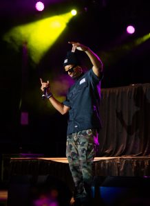A man in a camouflage shirt standing on a stage.