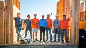 A group of construction workers posing in front of a building.