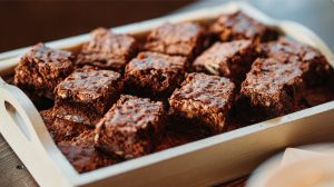 Chocolate brownies in a wooden tray on a table.