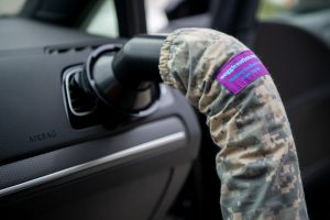 A car with a camouflage cover on the steering wheel.