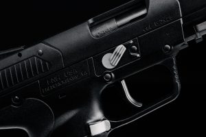 A black pistol on a black background.