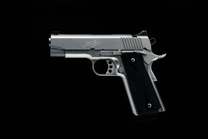 A silver pistol on a black background.
