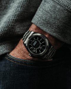 A close up of a man's wrist with a black watch.