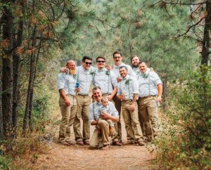 Groomsmen posing for a picture in the woods.