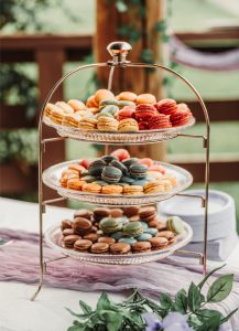 Three tiers of macarons on a table.