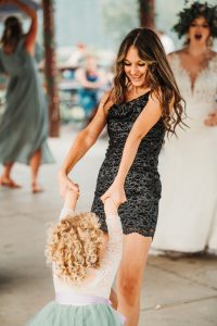 A woman in a dress dancing with a little girl.